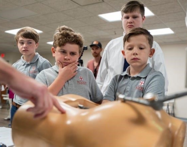 Students observing demonstration on medical mannequin