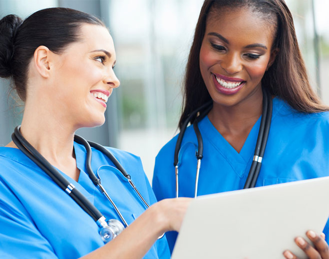 Two clinicians reviewing information on tablet
